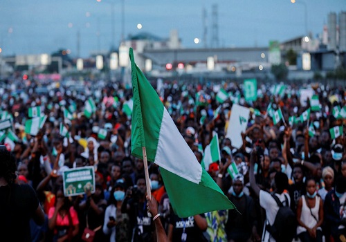 Nigerian youths holding national flag at a rally
