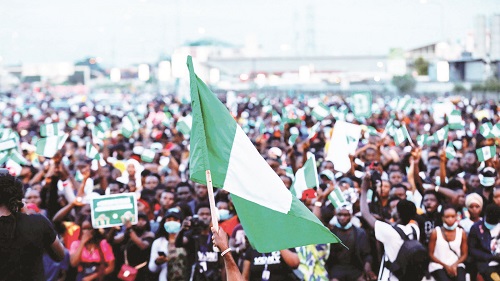 Nigerian youths holding national flag at a rally-1